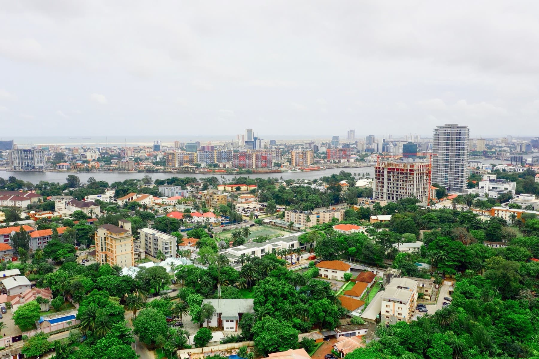 An aerial view over Ikoyi, Lagos, looking towards the city's high-rise skyline.